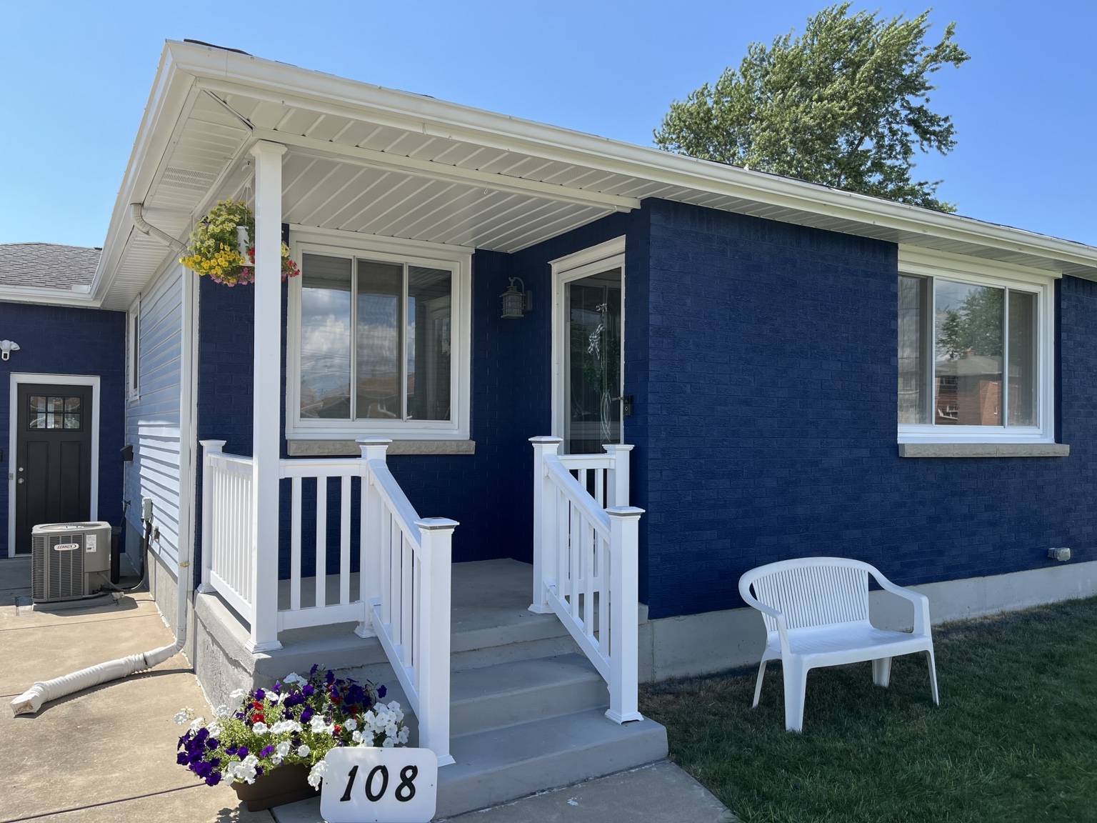 Finished navy brick exterior with white trim and porch railings